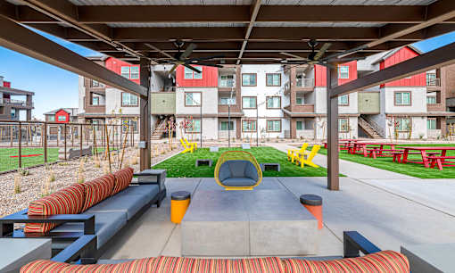 A modern outdoor seating area with a concrete table and chairs.