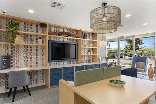 A conference room with a long table, chairs, and a television on a wall with a patterned wallpaper.at The 89 on Hayden, Arizona, 85257