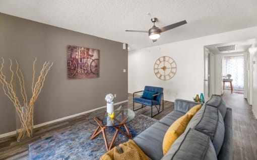 a living room with a couch and a clock on the wall  at Glen Brae, Glendale, AZ, 85301