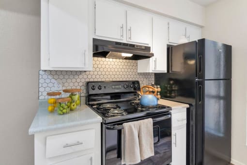 a kitchen with black appliances and white cabinets  at Glen Brae, Arizona, 85301