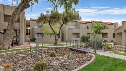 an apartment building with a courtyard with cactus and rocks at Glen Brae, Arizona