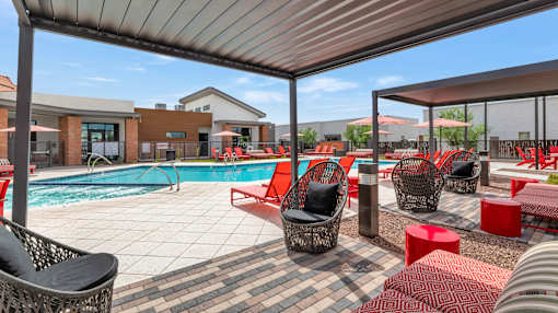 A poolside area with red and black furniture at Marketside Villas at Verrado, Buckeye, AZ