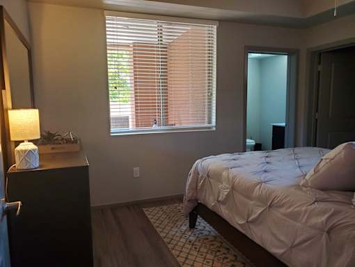 Bedroom with ensuite bathroom and wood flooring at Pinon Lofts Apartments, Arizona, 86336