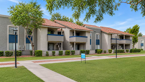 Apartment complex with a blue sign in front.