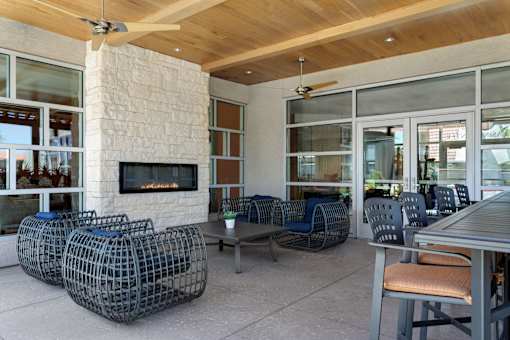 A patio with a fireplace and chairs at Denim Scottsdale, Scottsdale, AZ