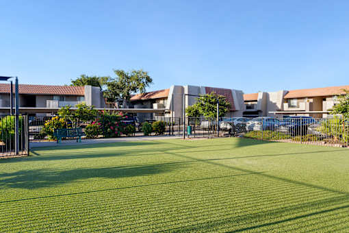 A grassy area in front of a building with a fence at Denim Scottsdale, Scottsdale, AZ