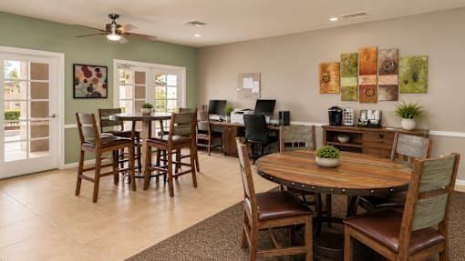 A dining room with a table surrounded by chairs.