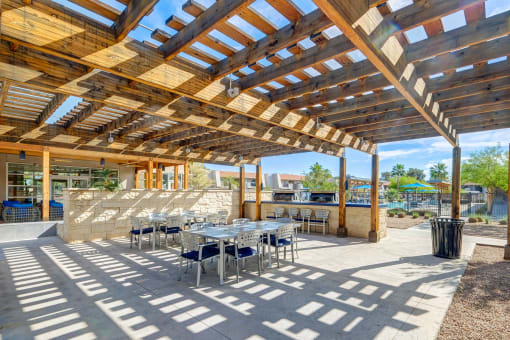 a patio with tables and chairs and a pergola at Denim Scottsdale, Scottsdale