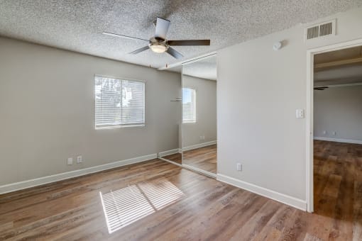the living room and dining room of an empty house with a ceiling fan at Denim Scottsdale, Scottsdale, AZ