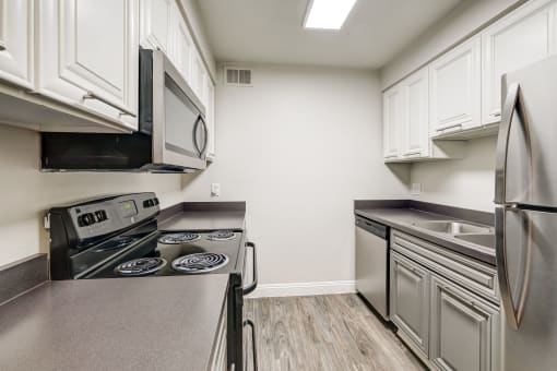 a kitchen with stainless steel appliances and white cabinets at Denim Scottsdale, Scottsdale, 85251