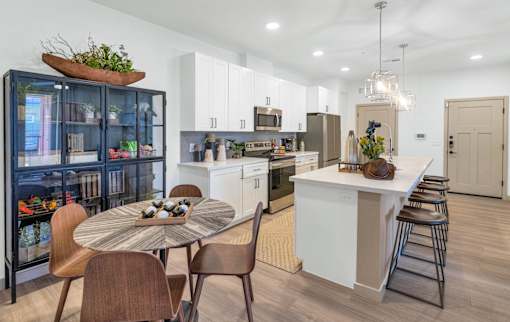 A modern kitchen with a dining table and chairs.
