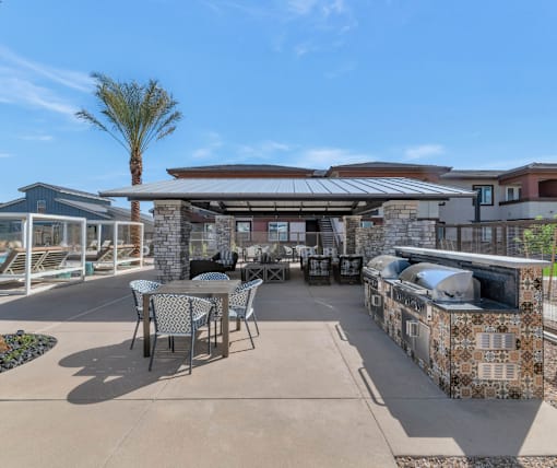 A patio with a table and chairs is surrounded by a stone wall.