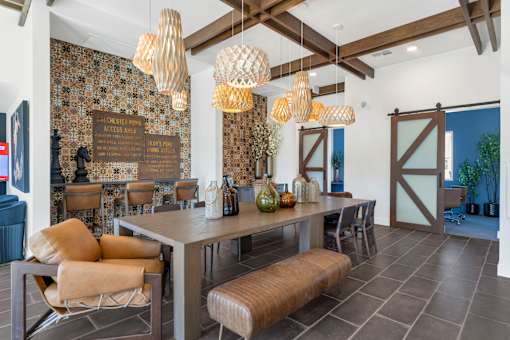 A dining room with a table and chairs and a wallpapered wall.