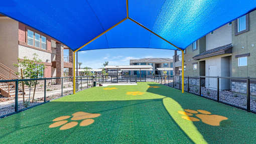 A playground with a green surface and yellow paw prints.