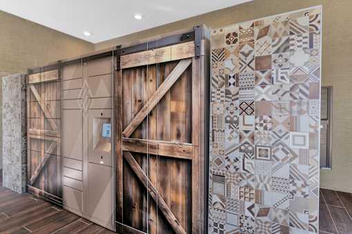 A large wooden door with a decorative tile wall on the side.