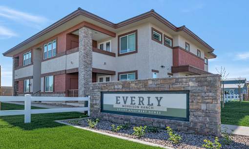 A modern house with a sign that reads "Everly" in front of it.