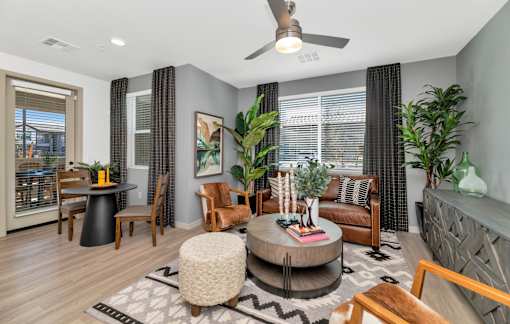 A living room with a round coffee table and a ceiling fan.