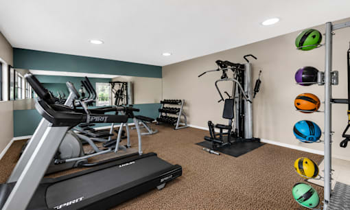 A gym with treadmills, exercise bikes, and weights.