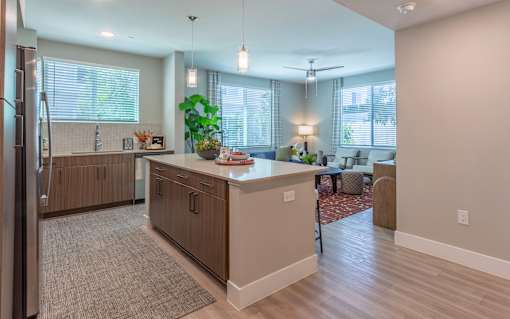 A kitchen with a refrigerator on the left and a dining area with a table and chairs.