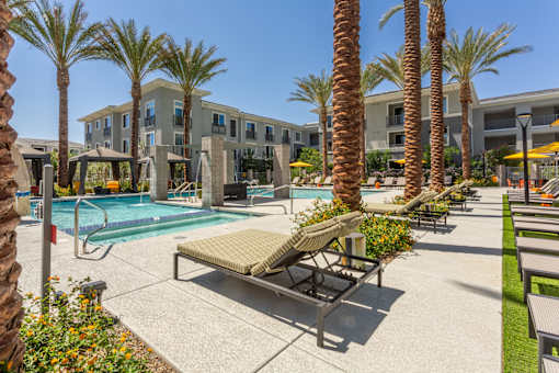 A pool surrounded by palm trees and a sun lounger.