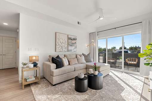 Modern living room with sliding glass door at Lucero Apartments, Phoenix, Arizona