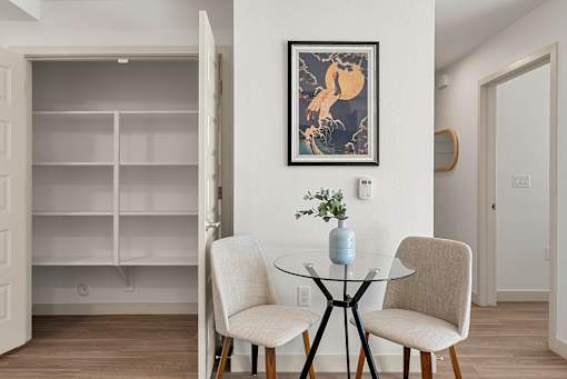 Dining area with glass table and builtin shelving at Lucero Apartments, Phoenix