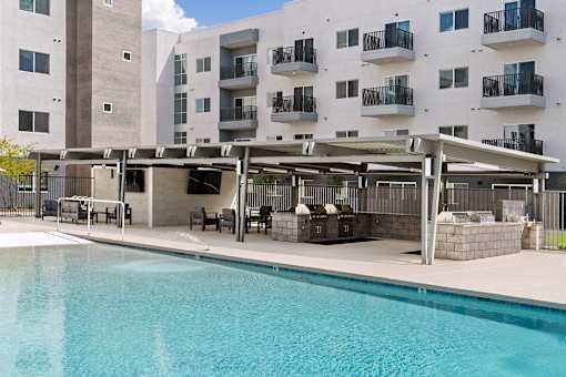 Resort style pool with covered barbecue area at Lucero Apartments, Phoenix