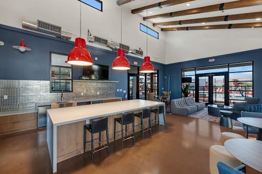 A modern kitchen with a long white island and bar stools.at Marketside Villas at Verrado, Buckeye, 85396