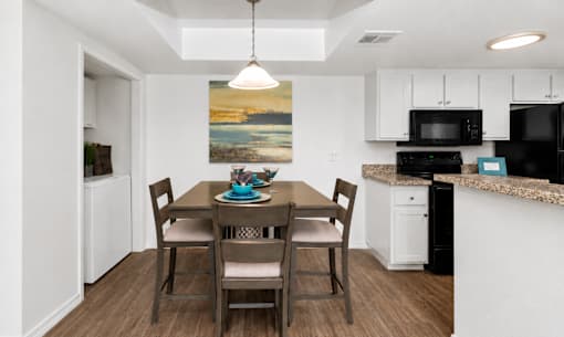 A dining room with a table set for four.