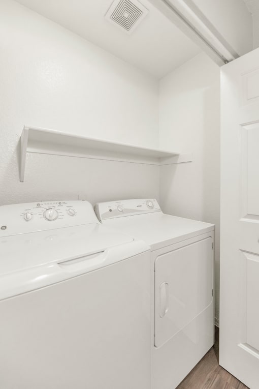 an empty laundry room with a washer and dryer