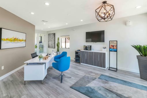 a living room with a desk and a chair and a tv