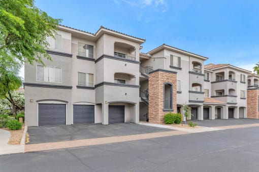 a street view of an apartment building with garage doors at Montage at Pecos Ranch Apartments, Chandler, 85286