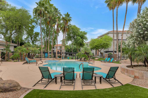 a swimming pool with patio furniture and palm trees at Montage at Pecos Ranch Apartments, Chandler, 85286