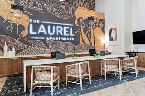 A conference room with a large table and chairs with a backdrop that says  at The Laurel Apartments, Chandler  
