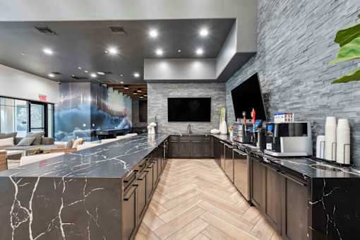 A modern kitchen with a marble countertop and wooden cabinets. at The Laurel Apartments, Chandler, 85286  