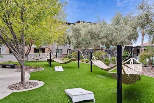 A backyard with a white hammock and a white bench. at The Laurel Apartments, Chandler Arizona  