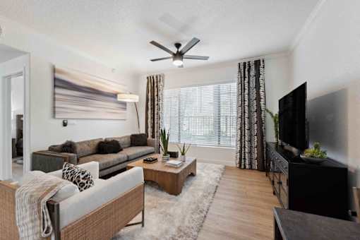 A living room with a grey couch and a wooden coffee table. at The Laurel Apartments, Chandler Arizona  