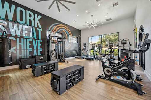 A gym with a variety of equipment including treadmills, weights, and a rowing machine. at Lazo Apartment Homes, Chandler Arizona  