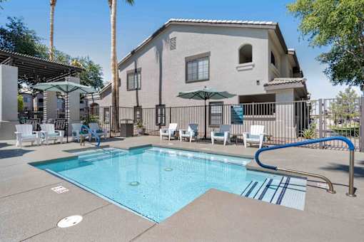 A swimming pool in front of a house with a blue tiled edge. at Lazo Apartment Homes, Arizona, 85225