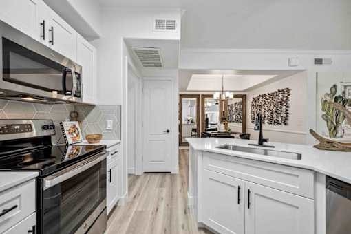 A kitchen with white cabinets and a black stove top oven. at Lazo Apartment Homes, Chandler, 85225  