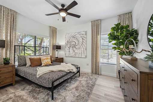 A bedroom with a bed, dresser, and ceiling fan. at Lazo Apartment Homes, Chandler  