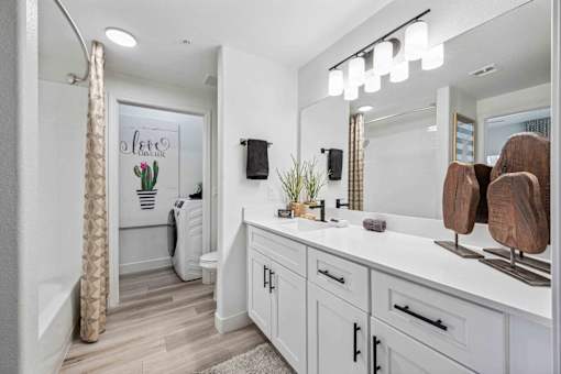 A bathroom with a white vanity and a shower area. at Lazo Apartment Homes, Chandler, AZ 85225  