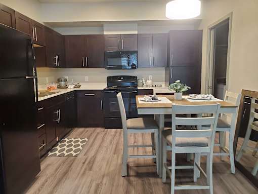 Modern kitchen with dining area and wood flooring at Pinon Lofts Apartments, Sedona, AZ
