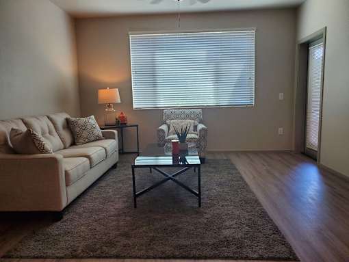 Living room with modern furniture and large window at Pinon Lofts Apartments, Sedona, 86336