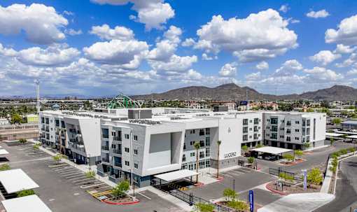 Modern apartment building exterior with parking area at Lucero Apartments, Phoenix, AZ 85051