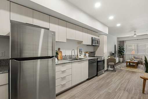 Modern kitchen with stainless steel appliances and granite countertops at Lucero Apartments, Phoenix, AZ