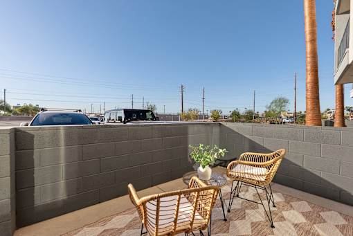 Private patio with wicker chairs and table at Lucero Apartments, Phoenix