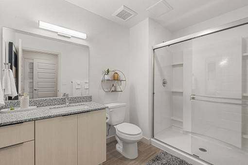 Bathroom with granite countertops and glass shower at Lucero Apartments, Arizona, 85051