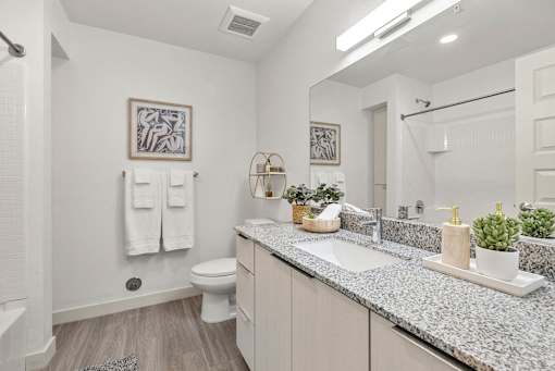 Bright bathroom with white subway tile and granite vanity at Lucero Apartments, Phoenix, AZ 85051
