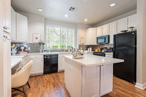 A kitchen with black appliances and white cabinets.at Palazzo Townhomes, Phoenix, AZ 85008  